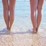 menstrualna čašica na plaži - dvije žene s nogama u moru