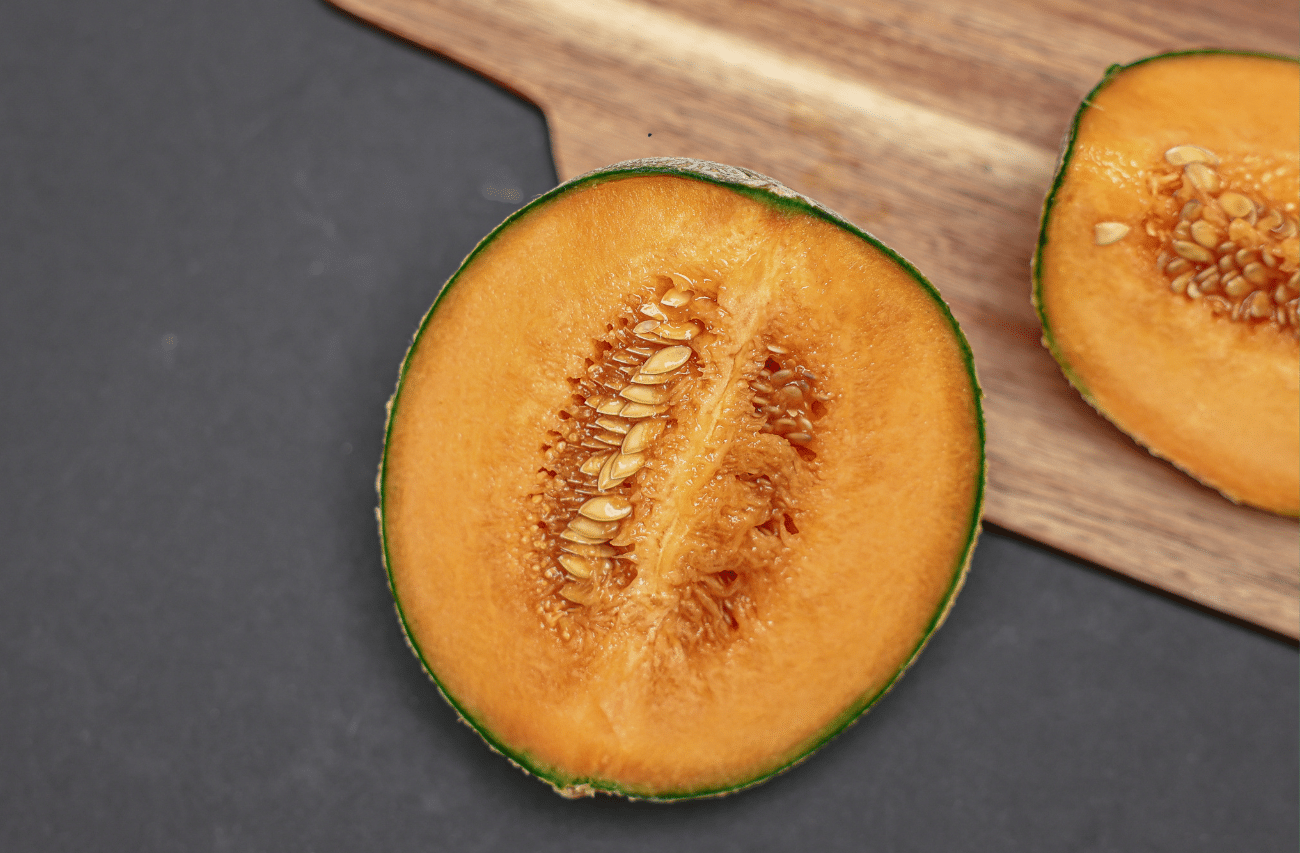 koštice dinje prepolovljena dinja na drvenoj dasci